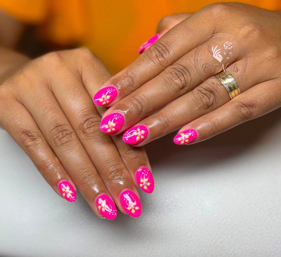 Neonroze nagels met gele bloemen en steentjes